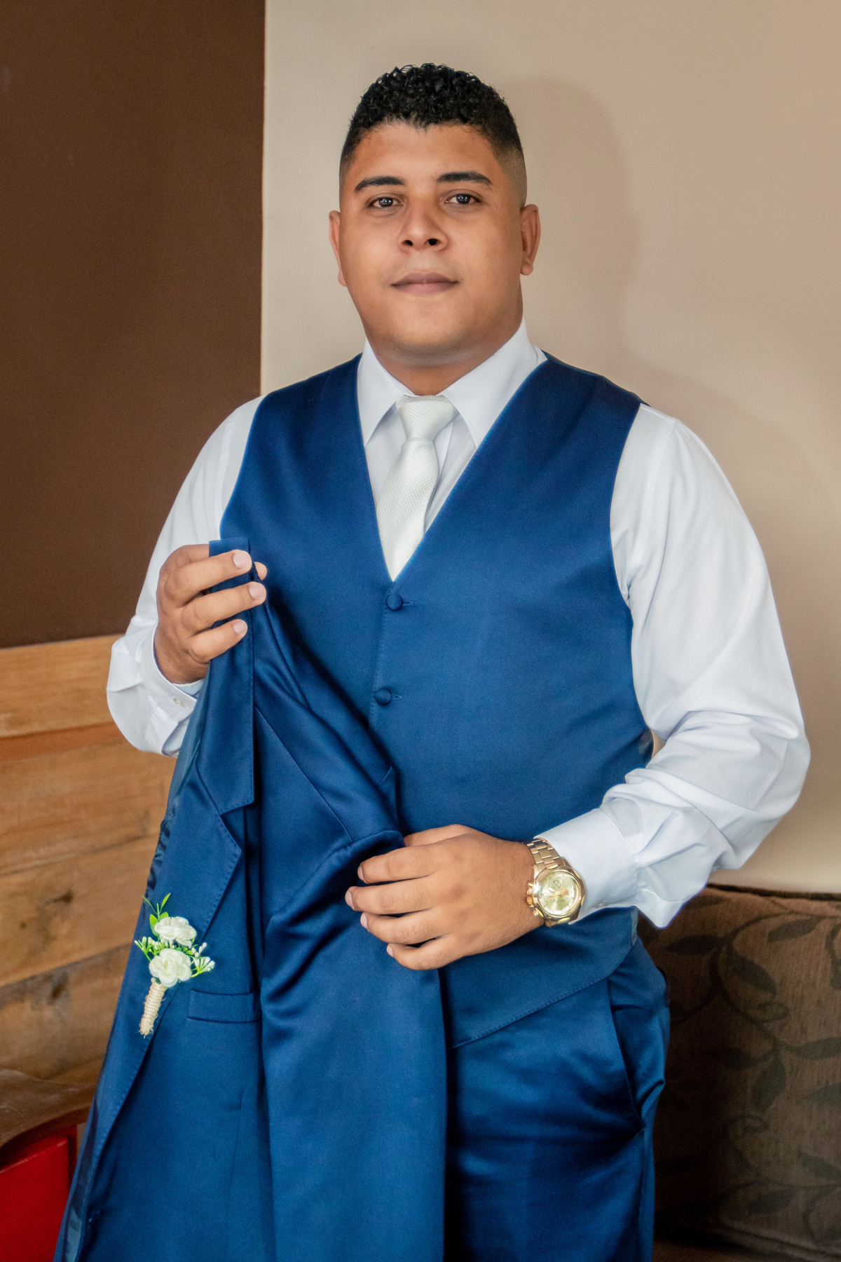 Noivo segurando seu Terno noivo azul escuro durante fotos do seu Making Of em casamento em Santo Antônio de Pádua interior do Rio de Janeiro.