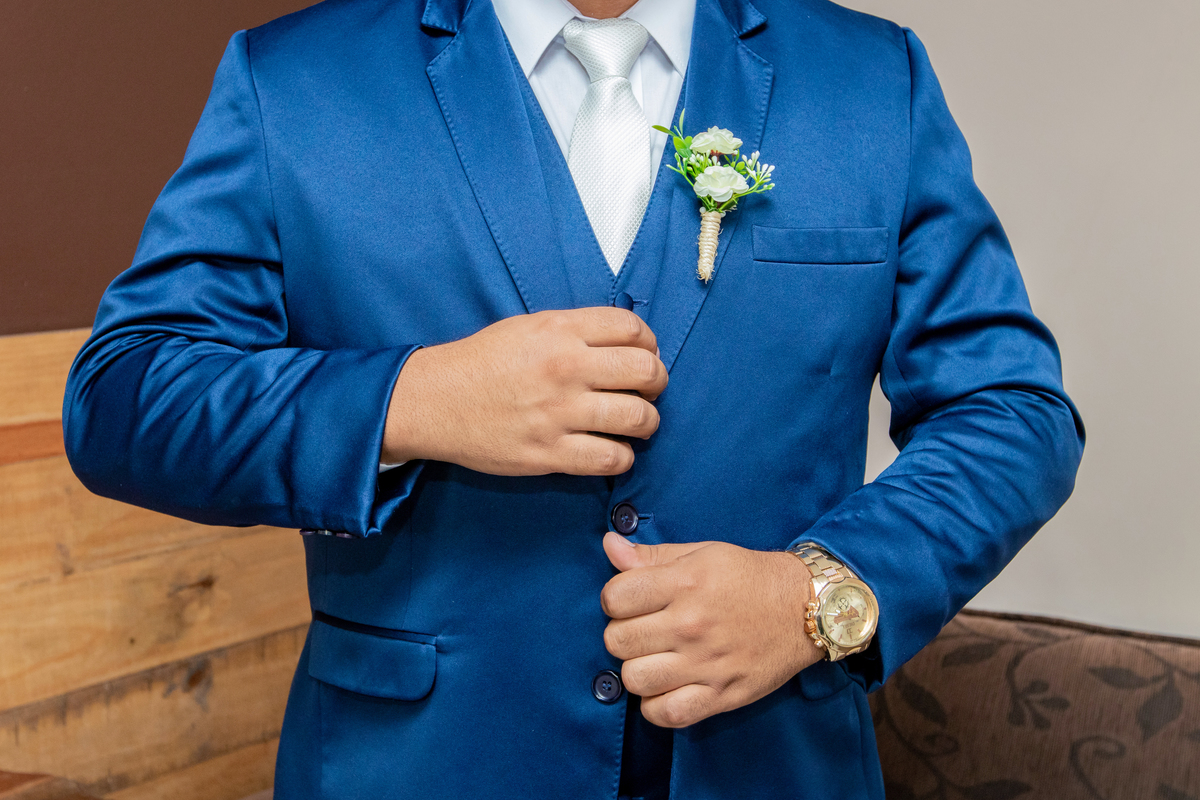 Noivo abotoando seu Terno noivo azul escuro durante fotos do seu Making Of em casamento em Santo Antônio de Pádua interior do Rio de Janeiro.