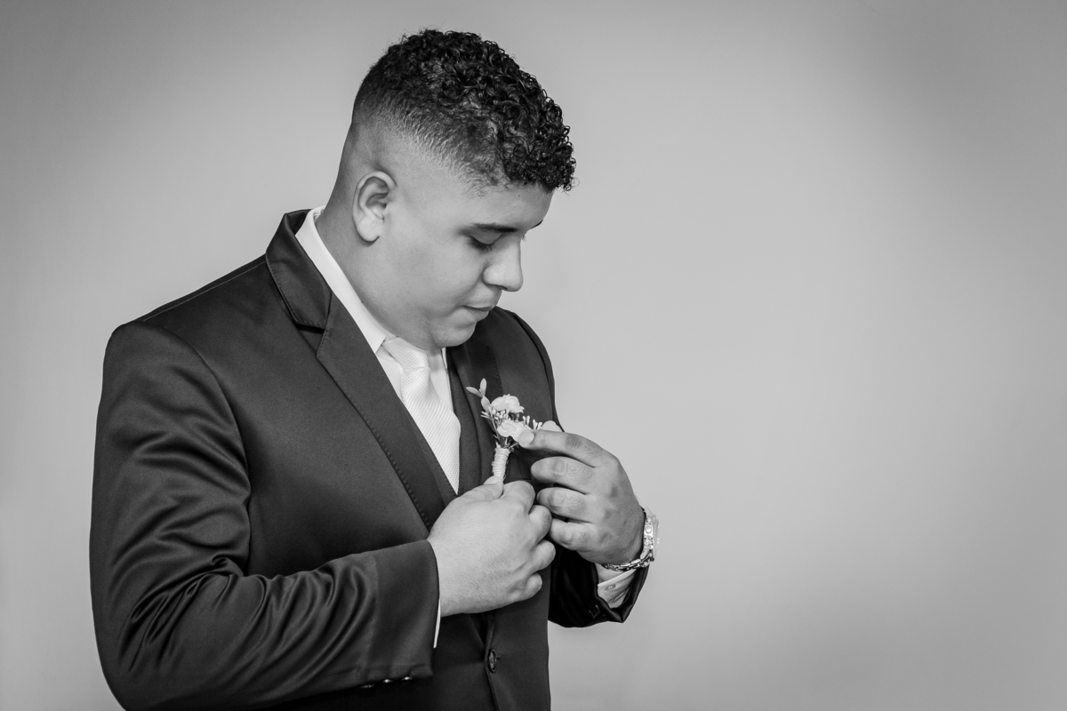 Foto em preto e brando do Noivo abotoando seu Terno noivo azul escuro durante fotos do seu Making Of em casamento em Santo Antônio de Pádua interior do Rio de Janeiro.