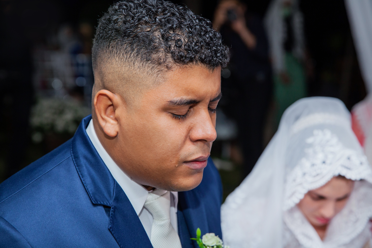 Noivo chorando emocionado com seu Terno noivo azul escuro durante casamento ao ar livre em Santo Antônio de Pádua interior do Rio de Janeiro. 