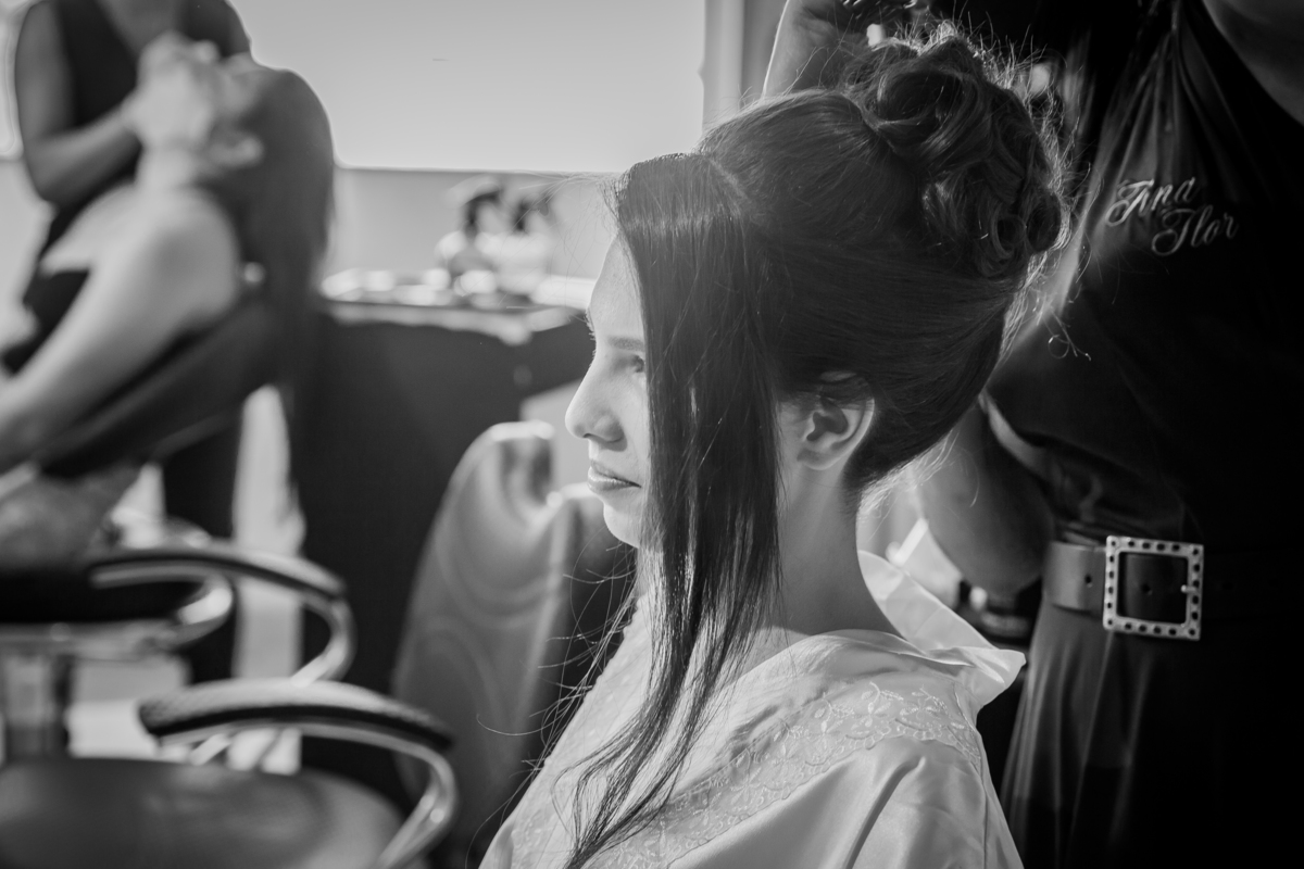 Foto em preto e branco da noiva fazendo o penteado em salão de beleza momentos antes doc casamento em salão de beleza em Pirapetinga para casamento em Santo Antônio de Pádua interior do Rio de Janeiro.