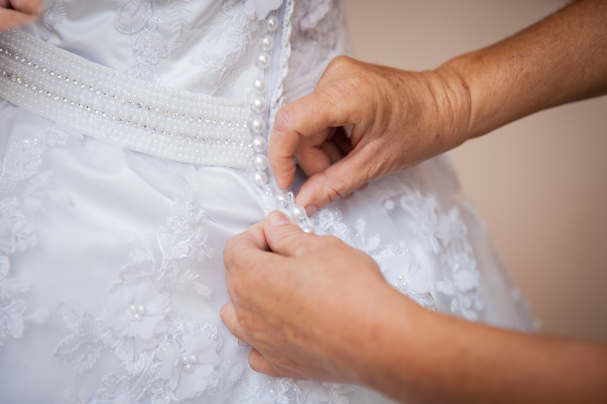 Detalhes do vestido da noiva em tela 3d com borboletas. Noiva se arrumando com sua mãe e sua sogra em salão de beleza momentos antes do casamento em salão de beleza em Pirapetinga para casamento em Santo Antônio de Pádua interior do Rio de Janeiro.