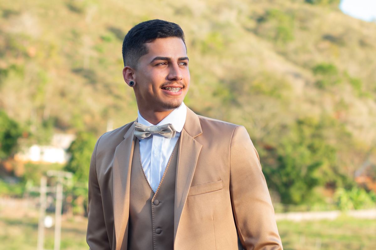 Making of do noivo ao ar livre, com terno dourado e gravata de borboleta em casamento durante o dia em Santo Antônio de Pádua no interior do Rio de Janeiro.