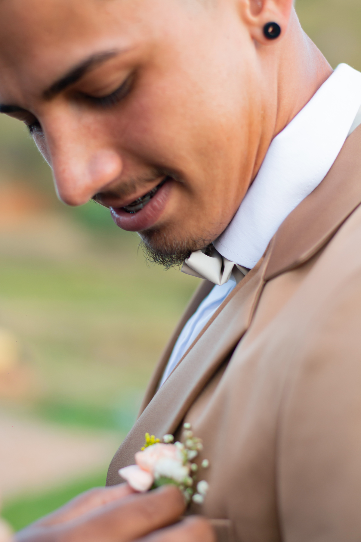 Making of do noivo ao ar livre, com terno dourado e gravata de borboleta em casamento durante o dia em Santo Antônio de Pádua no interior do Rio de Janeiro.