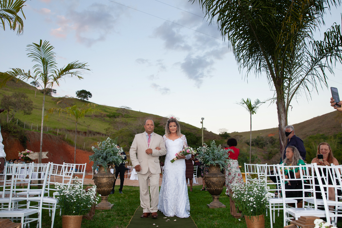 Noiva entrando com seu pai para seu casamento ao ar livre, durante o fim de tarde com um pôr do sol maravilhoso em Santo Antônio de Pádua no interior do Rio de Janeiro.