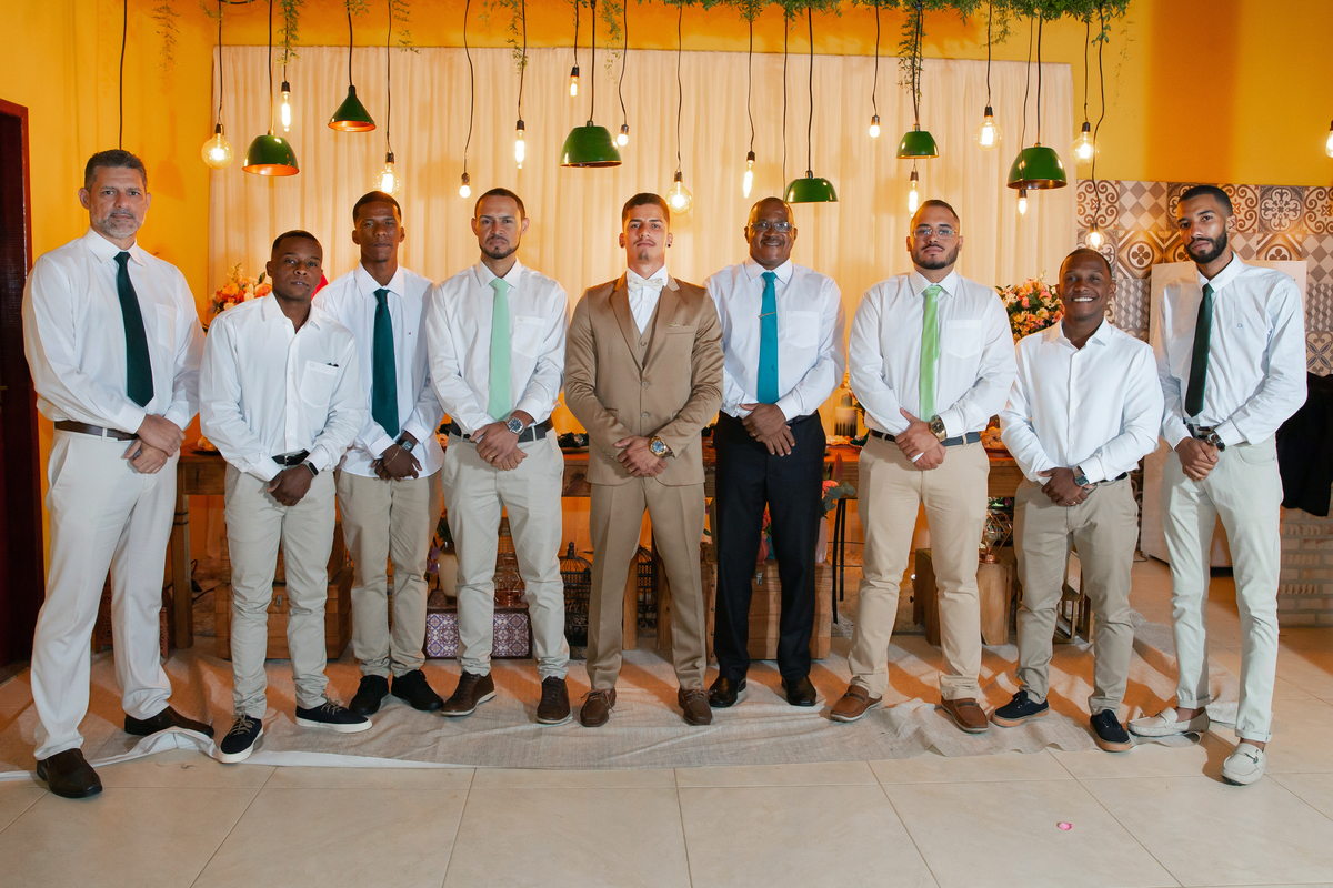Foto dos Padrinhos de gravata verde e noivo com terno dourado durante sessão de fotos em Casamento durante o dia ao ar livre  em Santo Antônio de Pádua no interior do Rio de Janeiro.