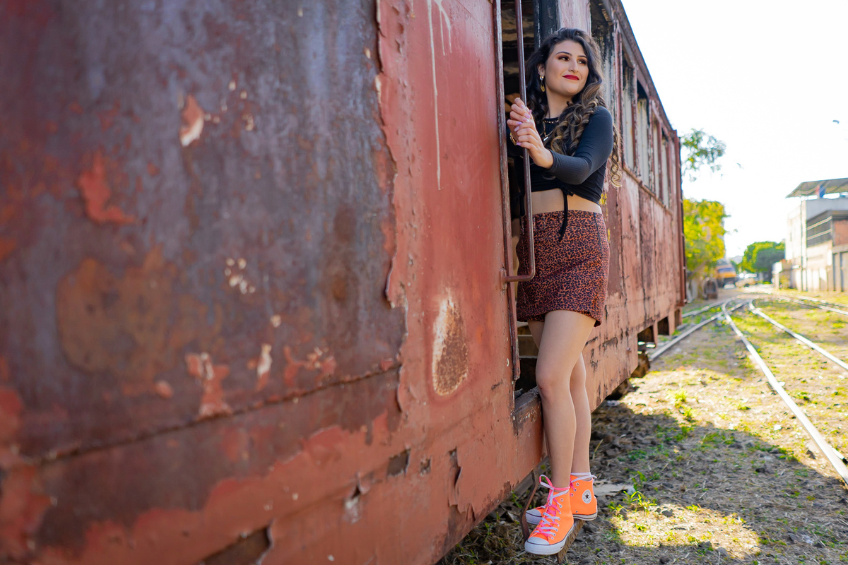 Ensaio de 15 anos em uma estação de trem antiga, a menina usando all satar laranja em um dia ensolarado em Santo Antônio de Pádua no interior do Rio de Janeiro.