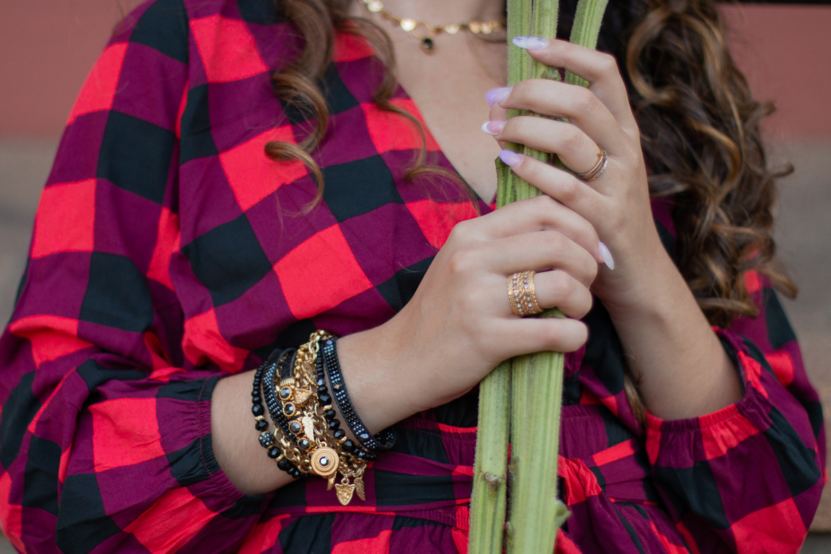 Ensaio de 15 , debutante sorrindo,  vestindo roupa xadrez e segurando flores girassóis em um dia ensolarado em Santo Antônio de Pádua no interior do Rio de Janeiro.