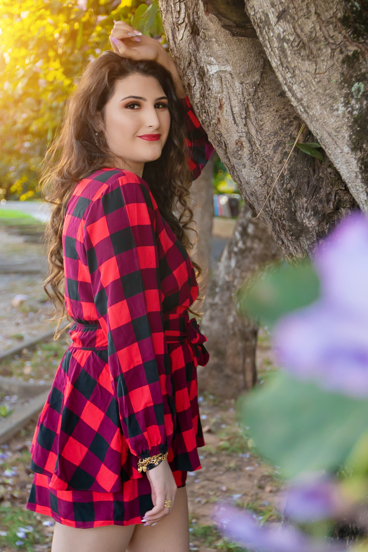 Ensaio de 15 , debutante sorrindo,  vestindo roupa xadrez em pôr do sol em um dia ensolarado em Santo Antônio de Pádua no interior do Rio de Janeiro.