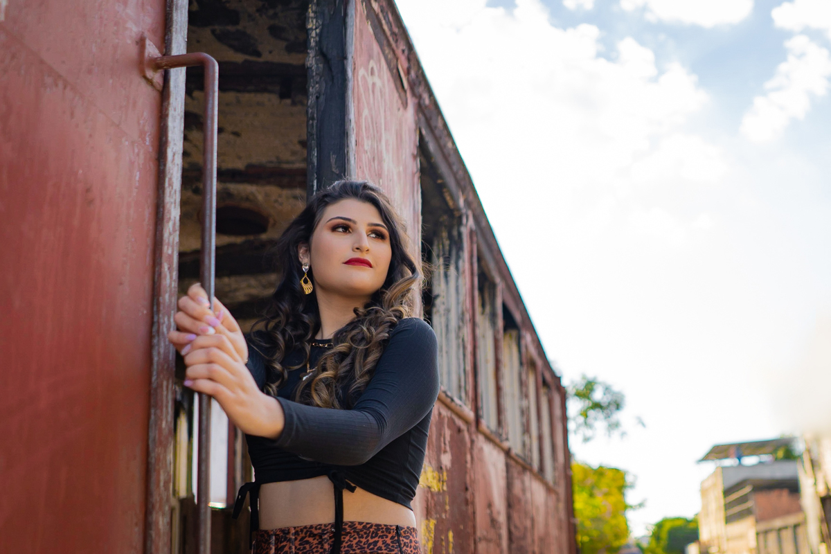 Ensaio de 15 anos em uma estação de trem antiga, a menina usando all satar laranja em um dia ensolarado em Santo Antônio de Pádua no interior do Rio de Janeiro.