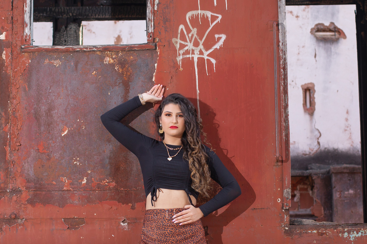 Ensaio de 15 anos em uma estação de trem antiga, a menina usando all satar laranja, com um toper preto e um short saia em animal print em um dia ensolarado em Santo Antônio de Pádua no interior do Rio de Janeiro.