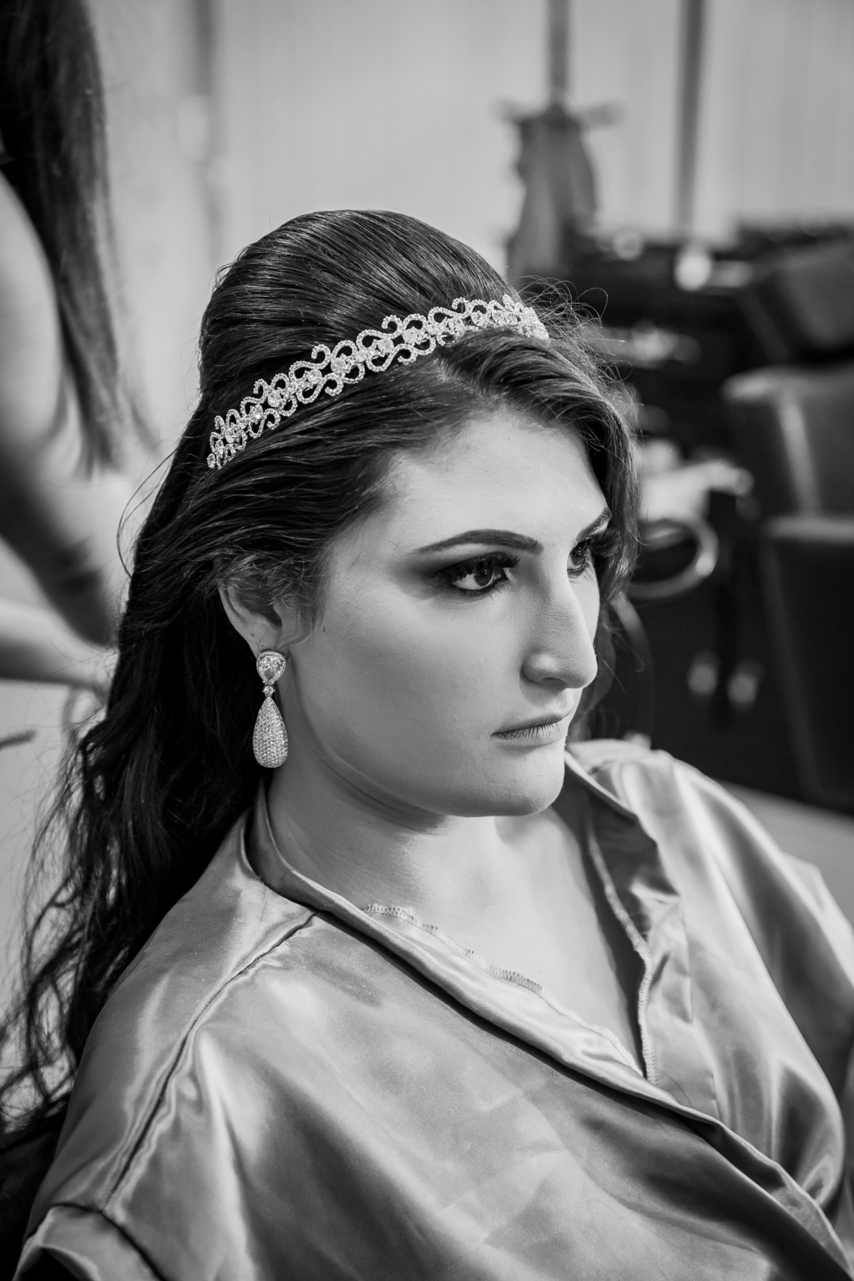 Foto em preto e branco. Making Of festa de 15 anos, debutante lindo com hobby dourado sendo maquiada em salão de beleza studio make mean angel em Santo Antônio de Pádua interior do Rio de Janeiro.