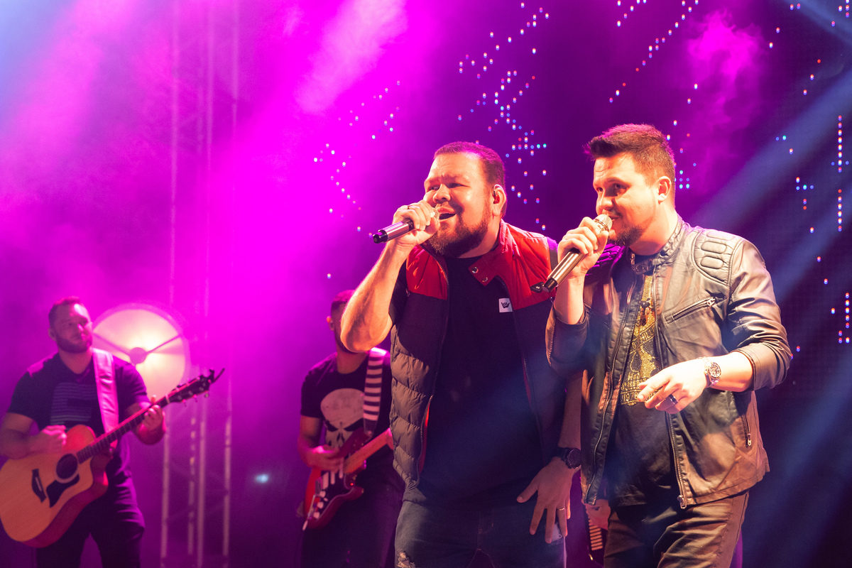 Debutante linda e feliz dançando com sua família em sua festa no palco com show ao vivo da dupla Júnior e Gustavo em salão de festa maison saintec ecile em Santo Antônio de Pádua interior do Rio de Janeiro.