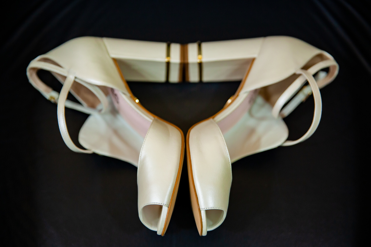 Making Of de debutante com detalhes dos brincos e tiara douradas e sapatos brancos lindos em salão de beleza studio make mean angel em Santo Antônio de Pádua interior do Rio de Janeiro.