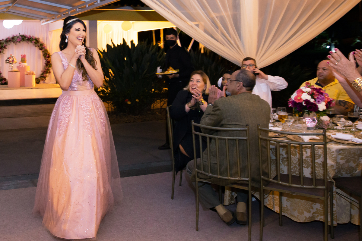 Debutante linda e feliz chegando em sua festa com decoração linda em tons vermelhos, rosa e dourado em maison saintec ecile em Santo Antônio de Pádua interior do Rio de Janeiro.