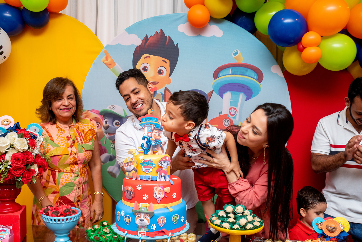 Aniversariante apagando a velinha do seu bolo de aniversário