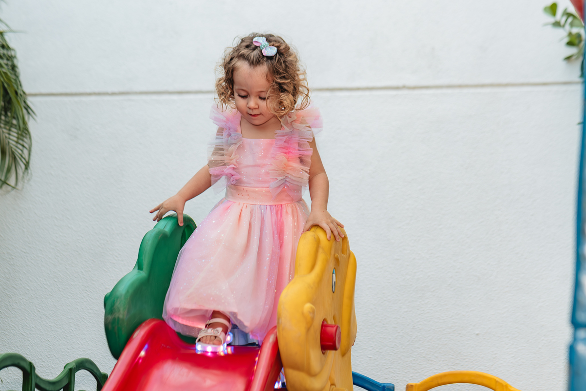 Menina 2 anos se divertindo no escorregador festa aniversário
