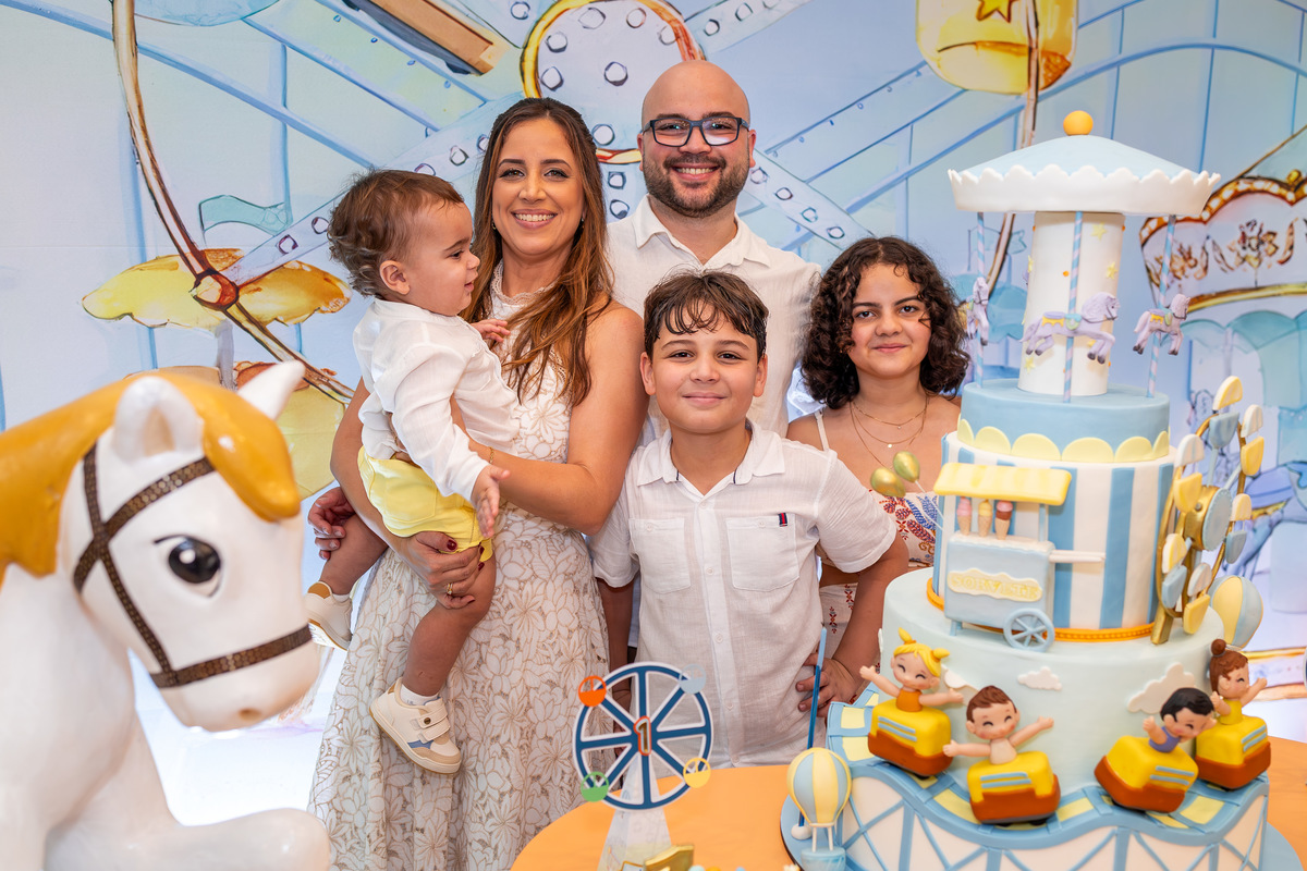 Pais e irmãos com Mateus no parabéns bolo Parque de Diversões