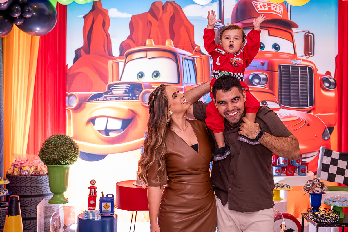 Levi interagindo com os pais, rindo e sendo abraçado durante a festa.