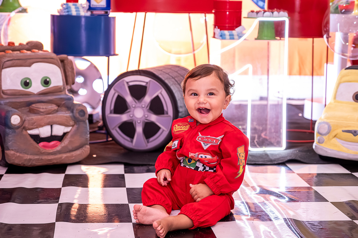 Levi interagindo com um brinquedo do tema Carros, em meio à festa de aniversário em Salvador.
