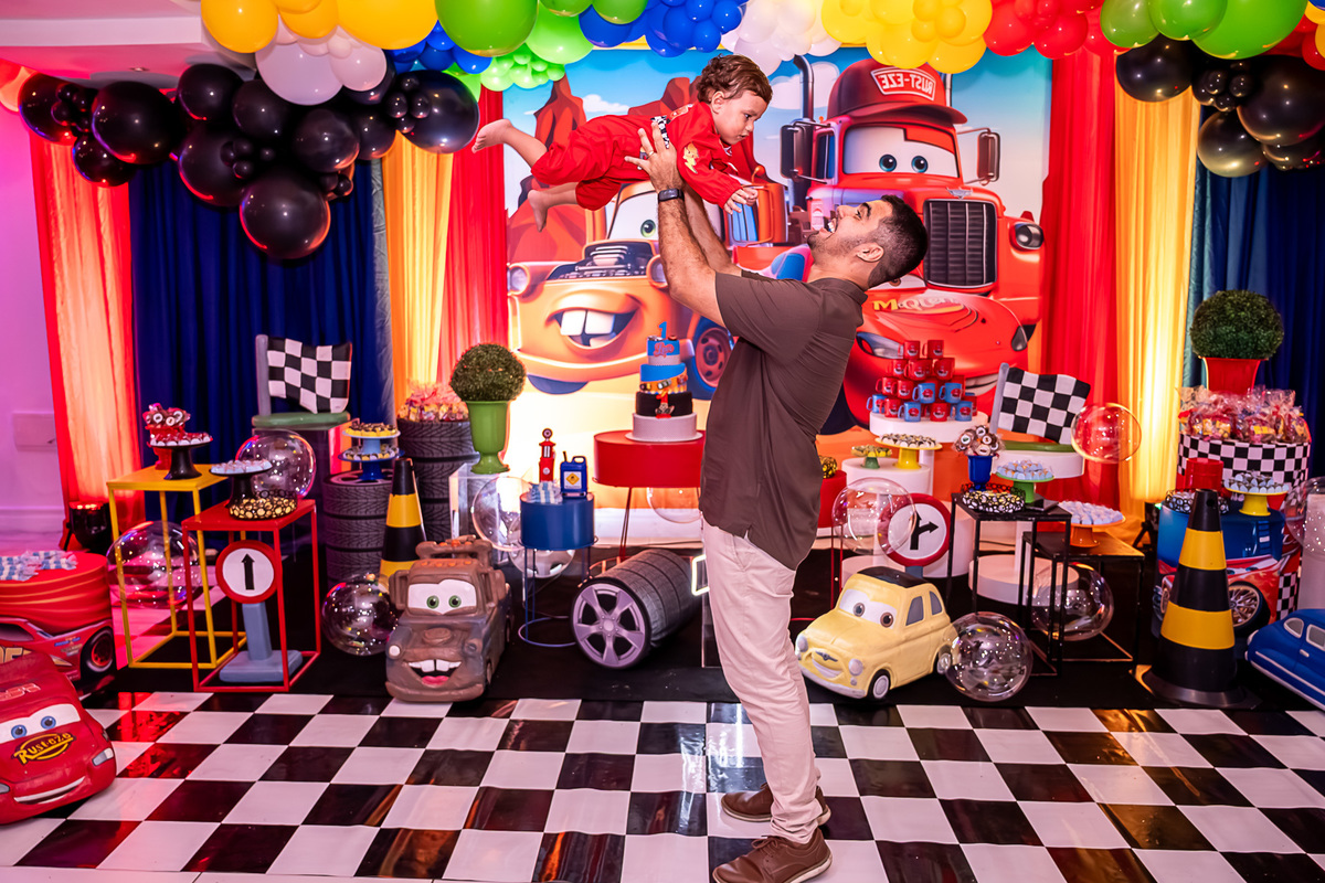 Levi no colo do pai, com um olhar de admiração, celebrando seu primeiro aniversário em Salvador.