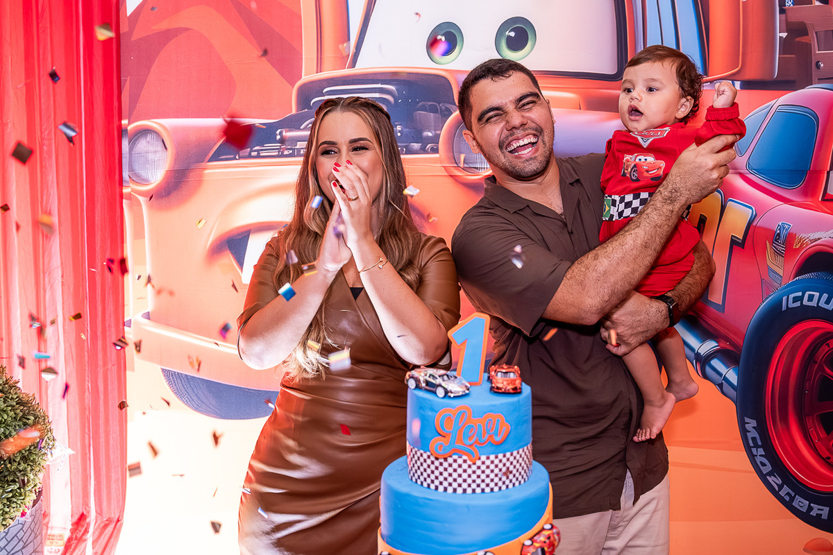 Pais do Levi cantando parabéns com alegria na festa de 1 ano, tema Carros, em Salvador, Bahia.