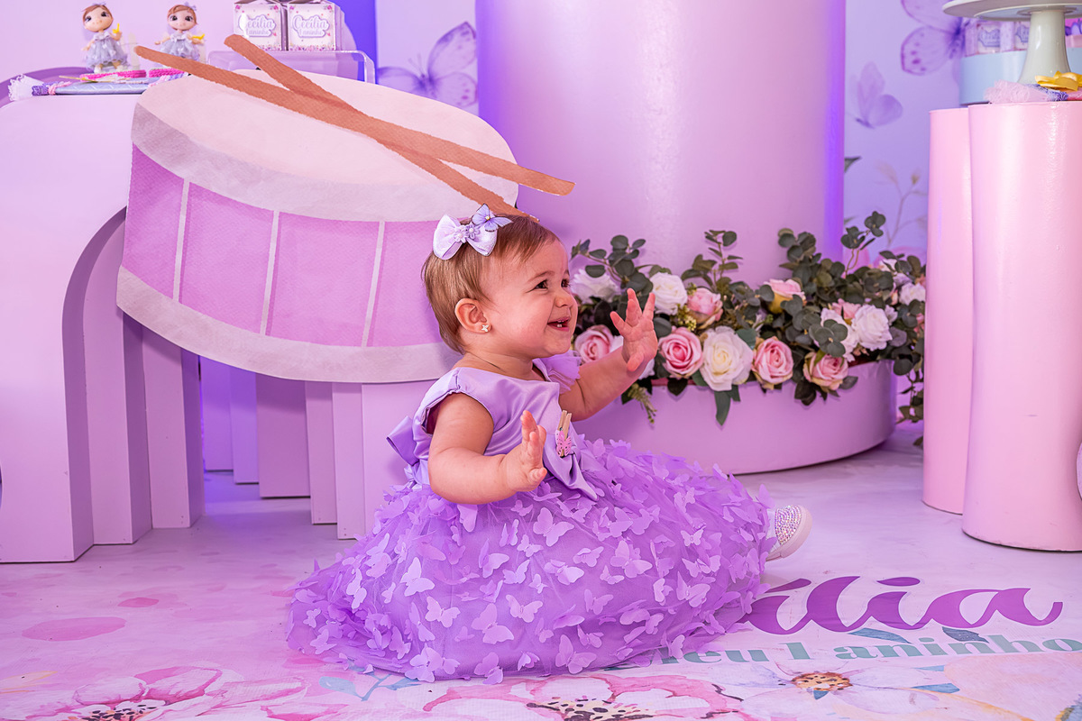  Cecília sentada em frente à decoração principal do 