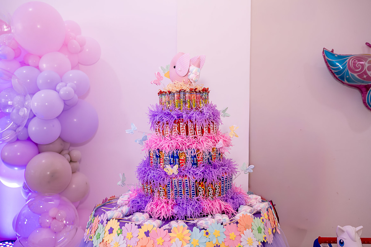 Close-up de um arranjo de flores e borboletas da decoração, destacando o trabalho da Laralá Festas Criativas.