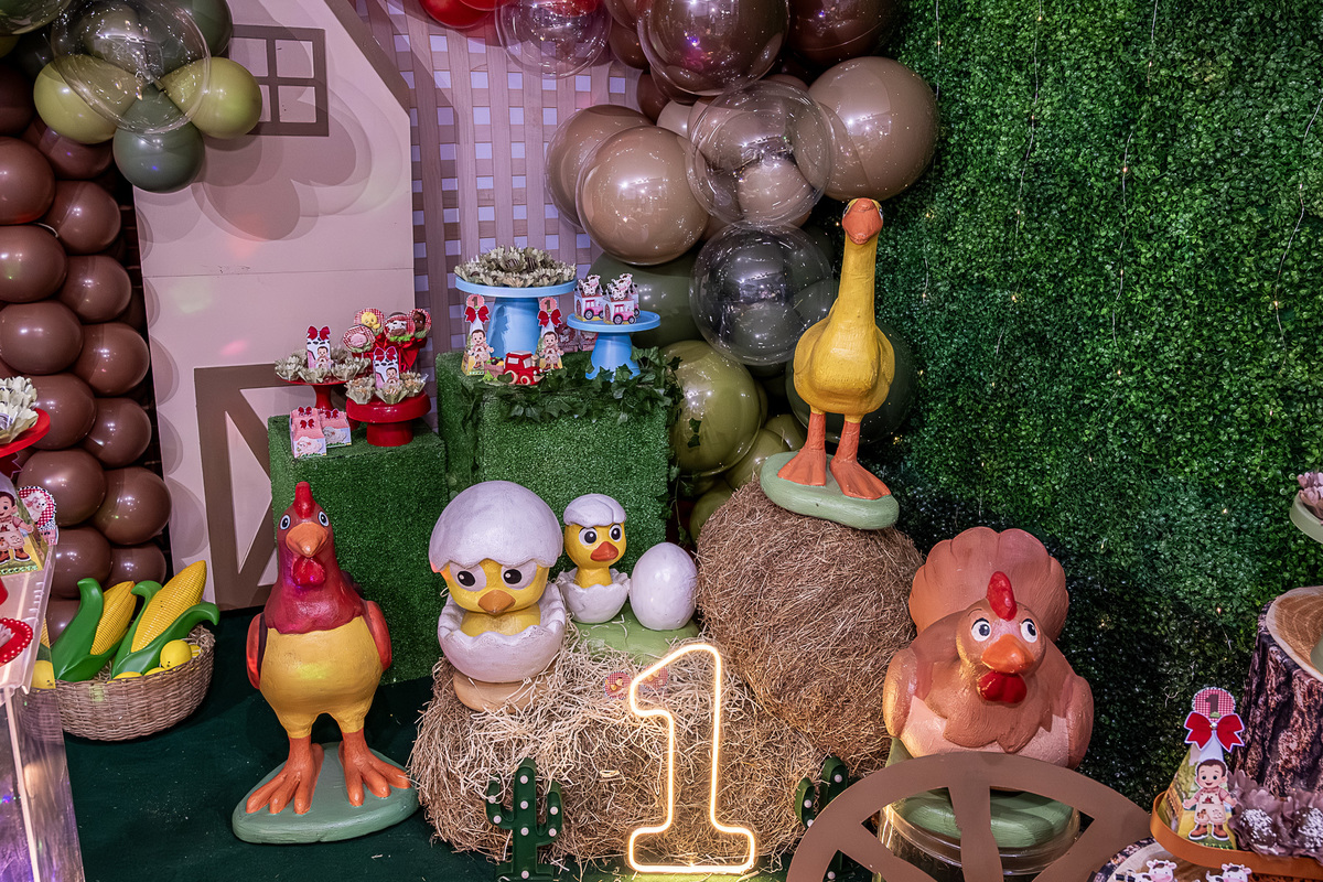 Detalhe da decoração Fazendinha: close-up dos bichinhos de pelúcia e elementos rústicos.