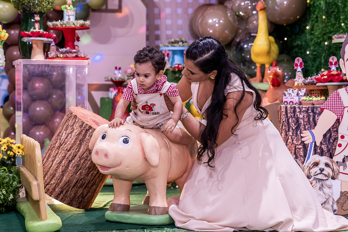 Renan com a mãe, em um momento de brincadeira e sorriso na festa Fazendinha.