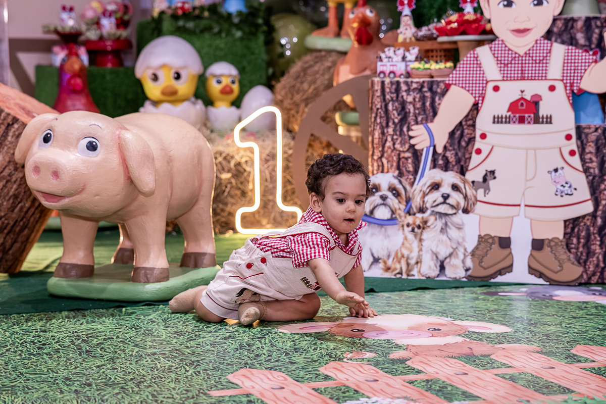 Renan rindo e apontando para a decoração da Fazendinha, em Vilas do Atlântico.