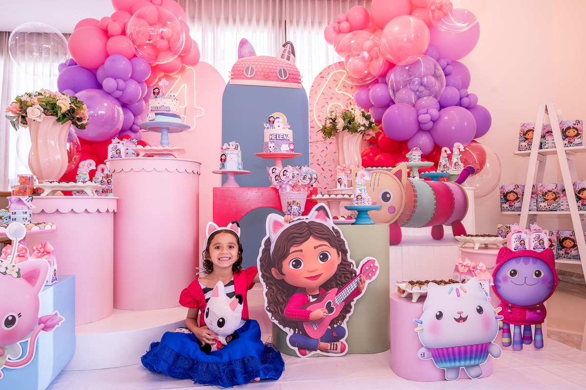 Helena em pose divertida, interagindo com a decoração do tema 