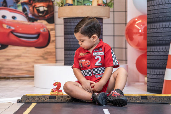 Aniversariante Guilherme sorrindo na festa tema Relâmpago McQueen no Candeal, Salvador – Pipoca Doce Fotos.