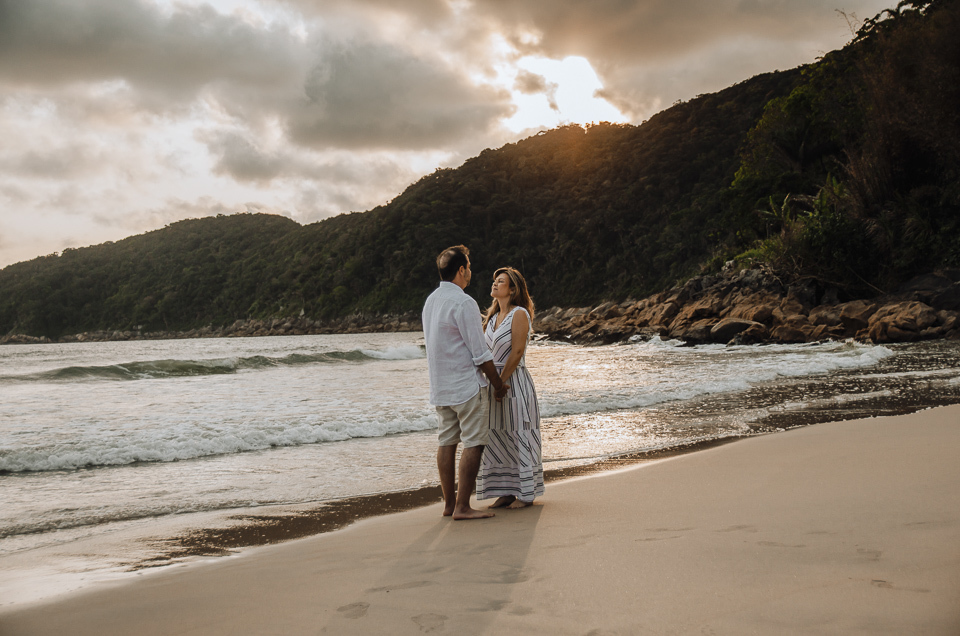 casal se olhando de frente a beira da agua