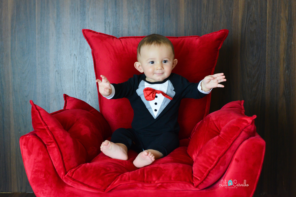 ensaio fotografico de menino, realizado em Maringá  poltrona vermelha 