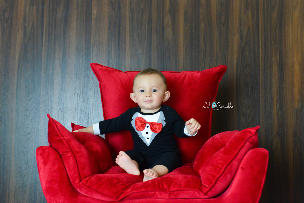 ensaio fotografico de menino, realizado em Maringá  mao na poltrona 