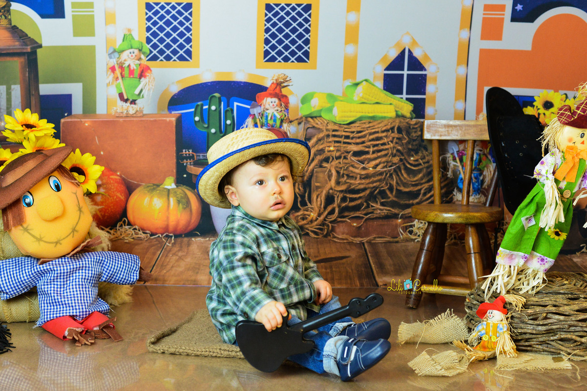 ensaio fotográfico realizado em estudio de menino, tema junino, camisa xadrez fofo