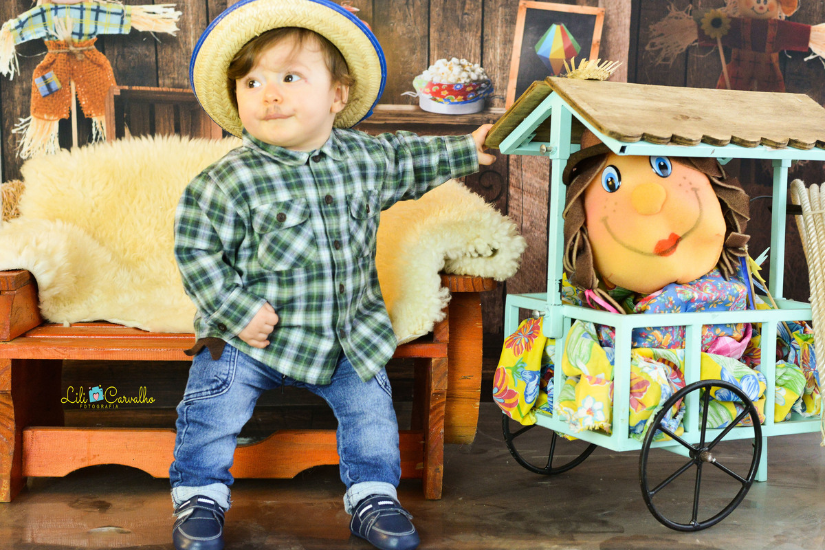 ensaio fotográfico realizado em estudio de menino, tema junino, camisa xadrez capirinha 