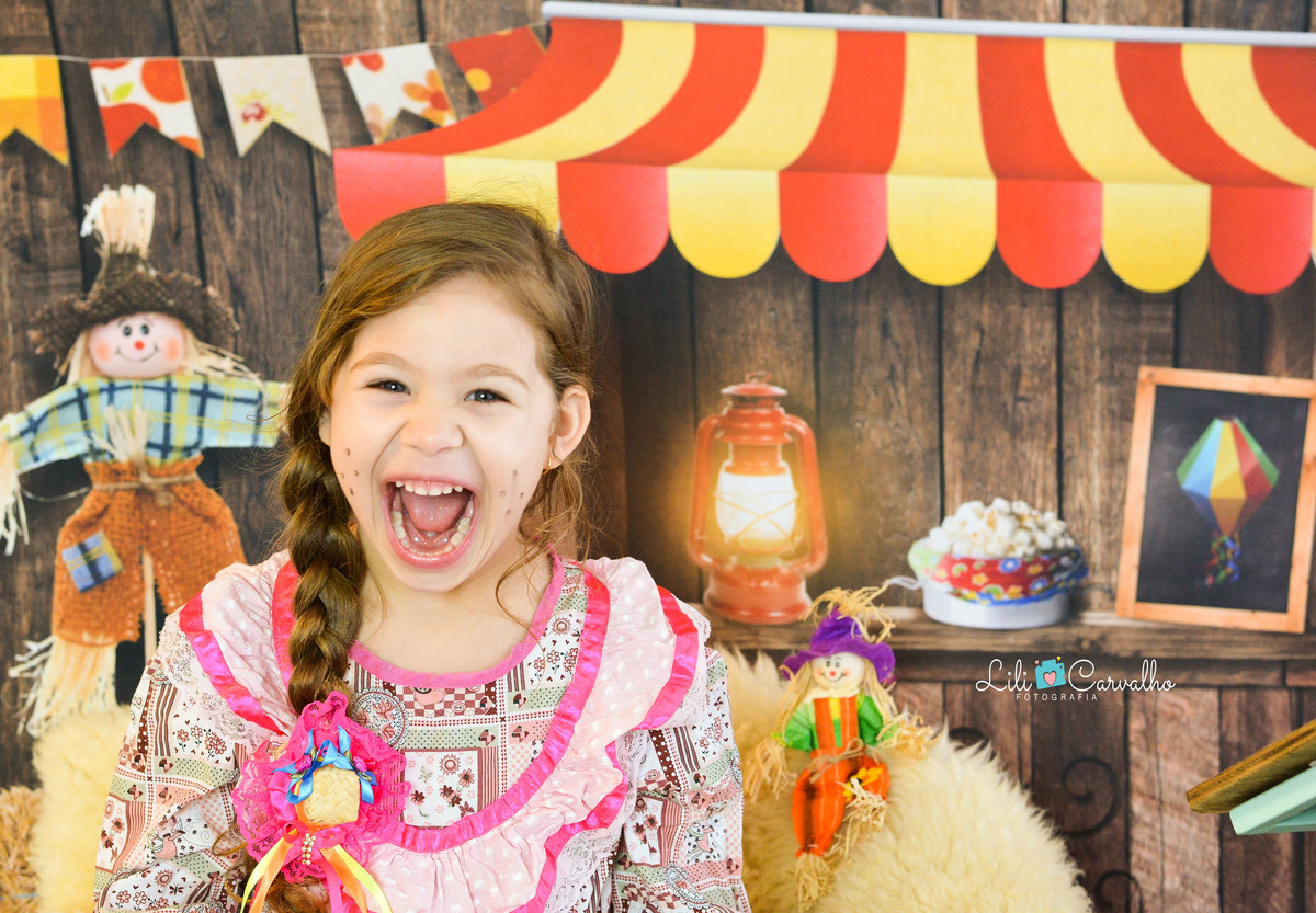 ensaio fotográfico realizado em estudio de menino, tema junino, camisa xadrez irmã 
