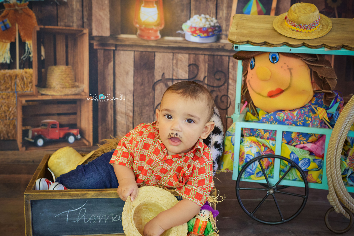 ensaio fotográfico realizado em estudio de menino segurando chapeu 