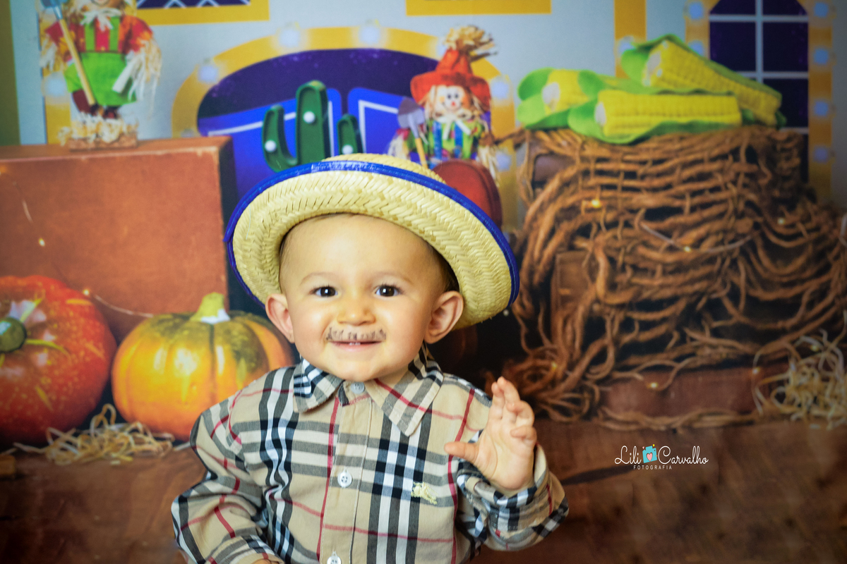 ensaio fotográfico realizado em estudio de menino sorrindo de bigode 