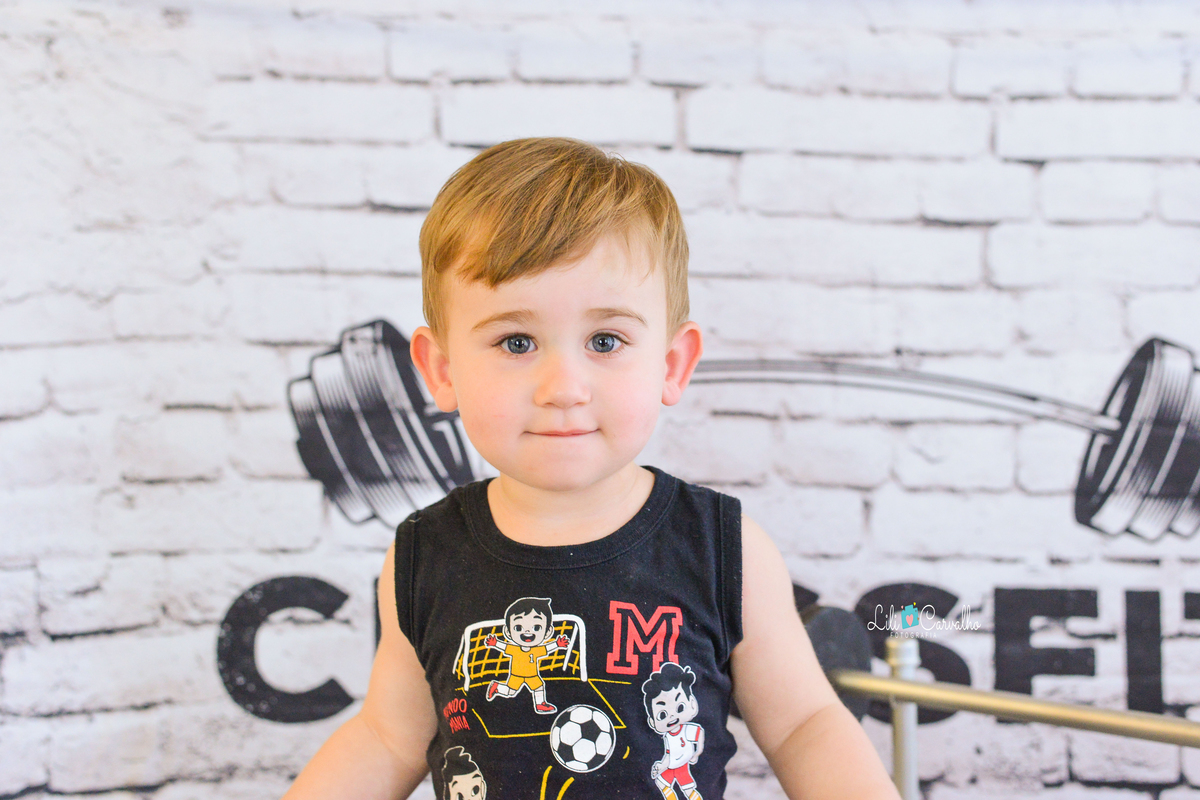 Ensaio fotografico de menino em estudio em Maringá segurando o riso