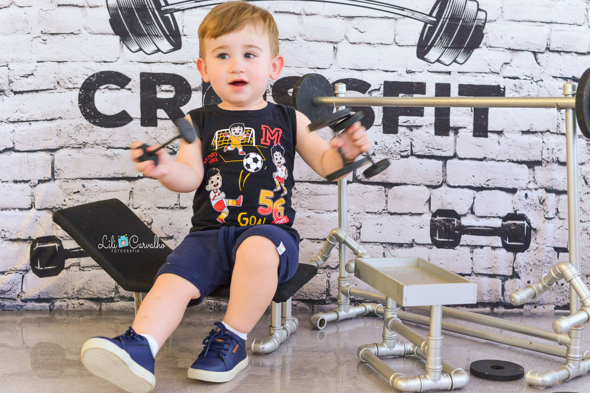 Ensaio fotografico de menino em estudio em Maringá segurando peso