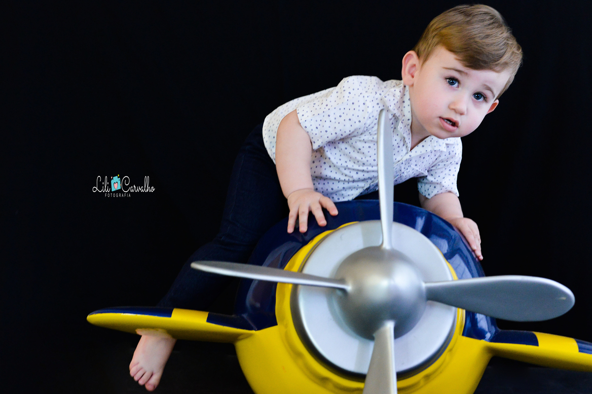 Ensaio fotografico de menino em estudio em Maringá subindo no aviao 
