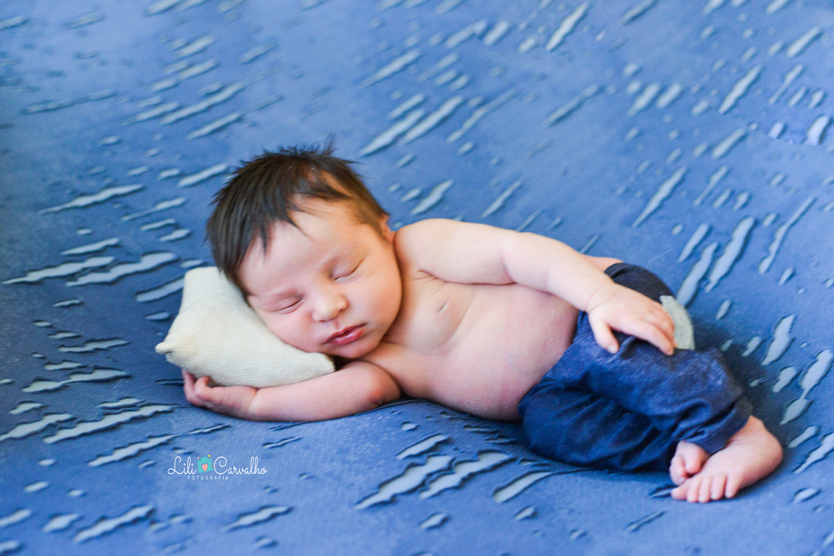 ensaio newborn realizada em estudio em Maringá, recem nascido menino mao no rosto
