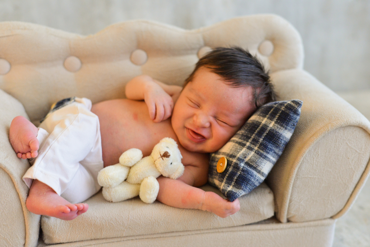 ensaio newborn realizada em estudio em Maringá, recem nascido menino sorriso e ursinho