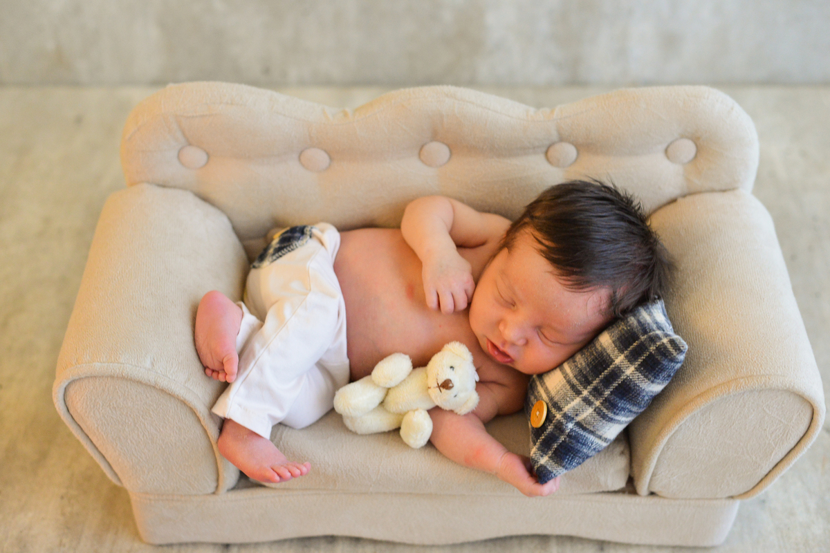 ensaio newborn realizada em estudio em Maringá, recem nascido menino deitado 