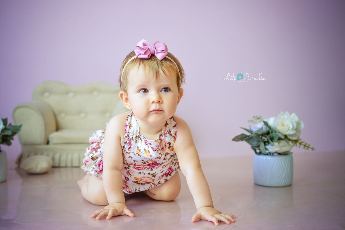 foto de bebê em ensaio no estúdio em Maringá engatinhando olhando para lado