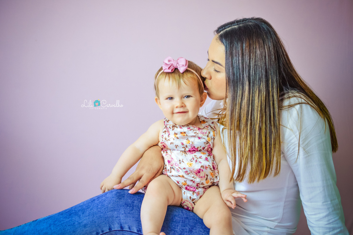 foto de bebê em ensaio no estúdio em Maringá ganhando beijo da mãe 