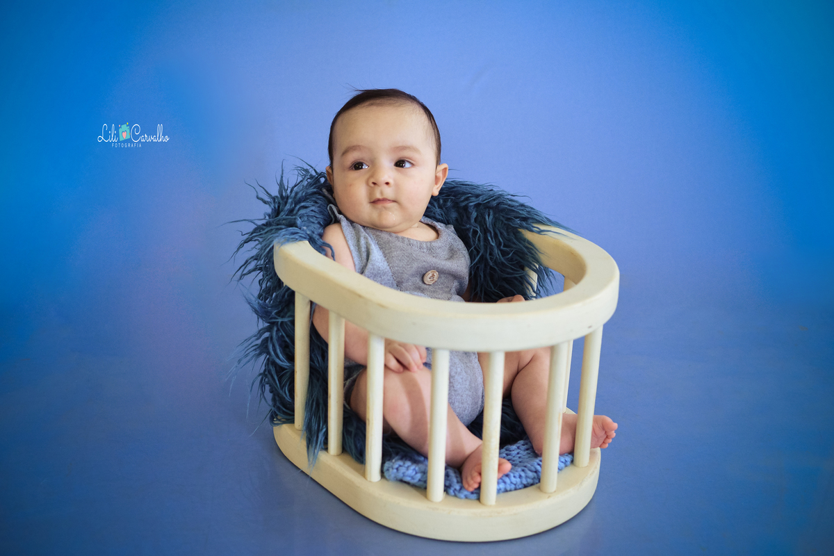ensaio fotografico de bebê menino no estudio em Maringá olhando para lado 